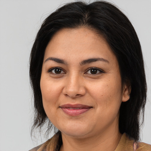 Joyful latino adult female with medium  brown hair and brown eyes