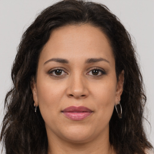 Joyful latino adult female with long  brown hair and brown eyes