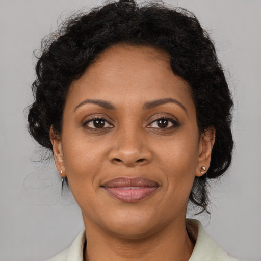 Joyful black adult female with medium  brown hair and brown eyes