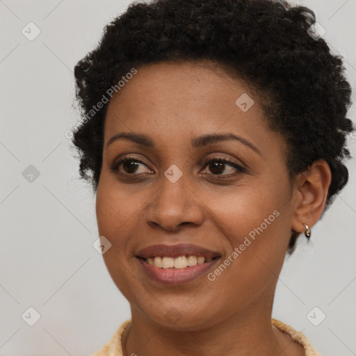 Joyful black young-adult female with short  brown hair and brown eyes