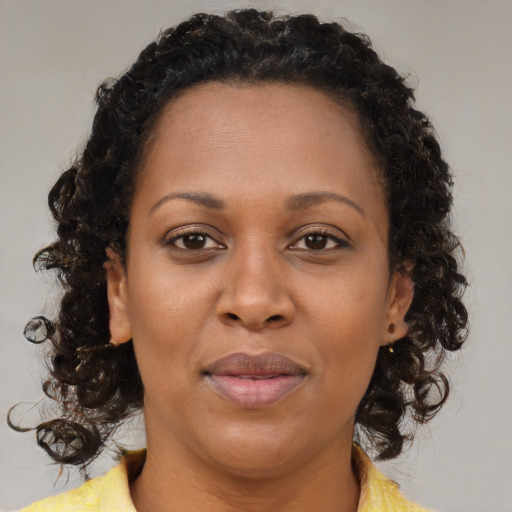Joyful black adult female with medium  brown hair and brown eyes