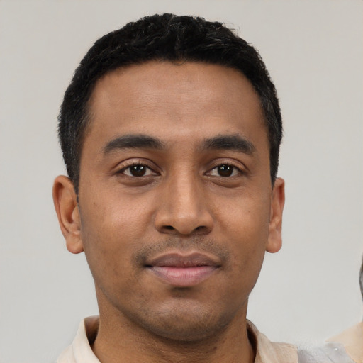 Joyful latino young-adult male with short  black hair and brown eyes