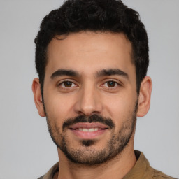 Joyful latino young-adult male with short  black hair and brown eyes