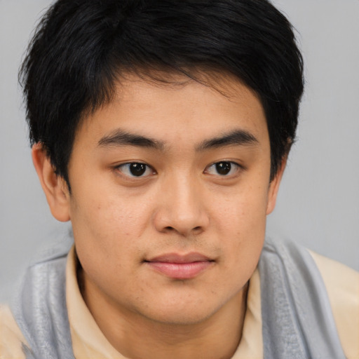 Joyful asian young-adult male with medium  brown hair and brown eyes