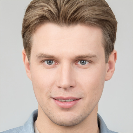 Joyful white young-adult male with short  brown hair and grey eyes