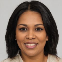 Joyful black adult female with medium  brown hair and brown eyes