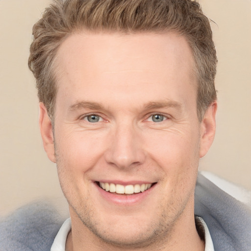 Joyful white adult male with short  brown hair and grey eyes