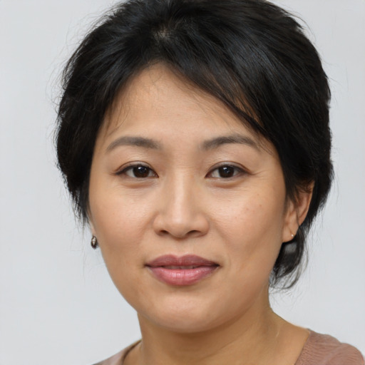 Joyful asian adult female with medium  brown hair and brown eyes