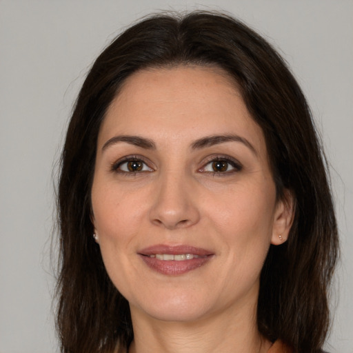 Joyful white adult female with long  brown hair and brown eyes