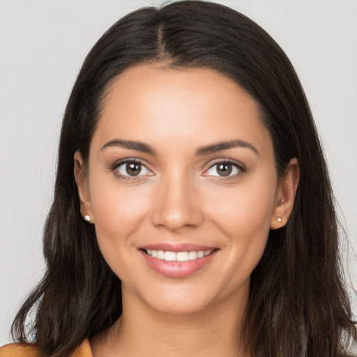 Joyful latino young-adult female with long  brown hair and brown eyes