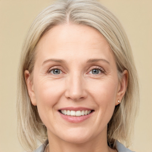 Joyful white adult female with medium  brown hair and blue eyes