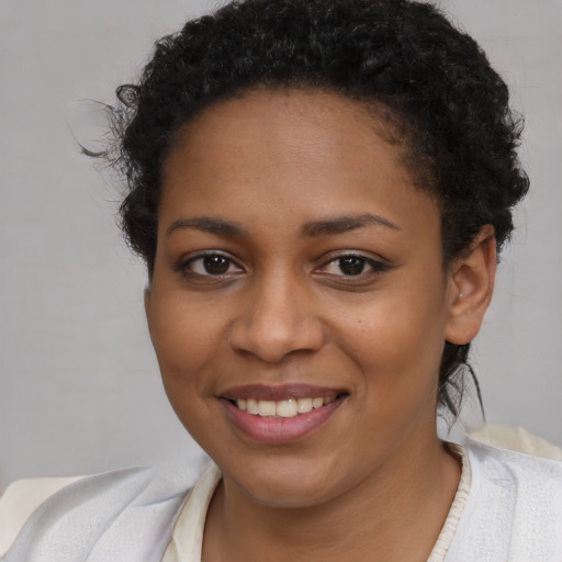 Joyful black young-adult female with short  brown hair and brown eyes