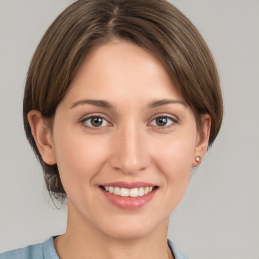 Joyful white young-adult female with medium  brown hair and grey eyes