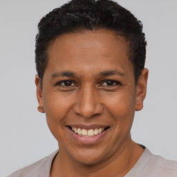 Joyful latino adult male with short  black hair and brown eyes