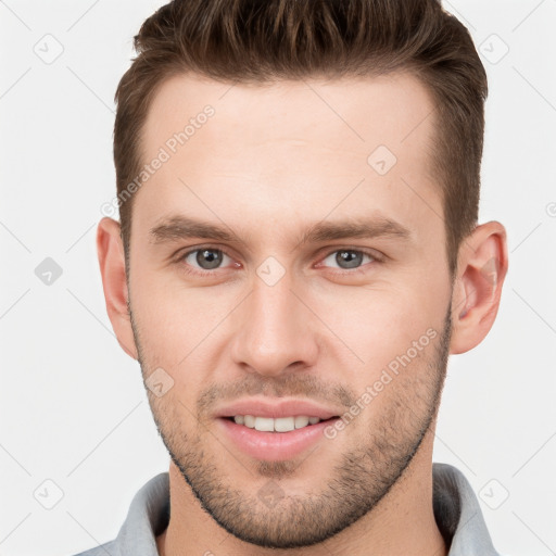 Joyful white young-adult male with short  brown hair and grey eyes