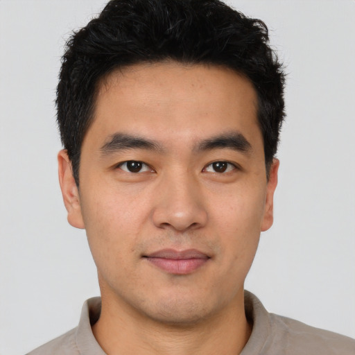 Joyful latino young-adult male with short  black hair and brown eyes
