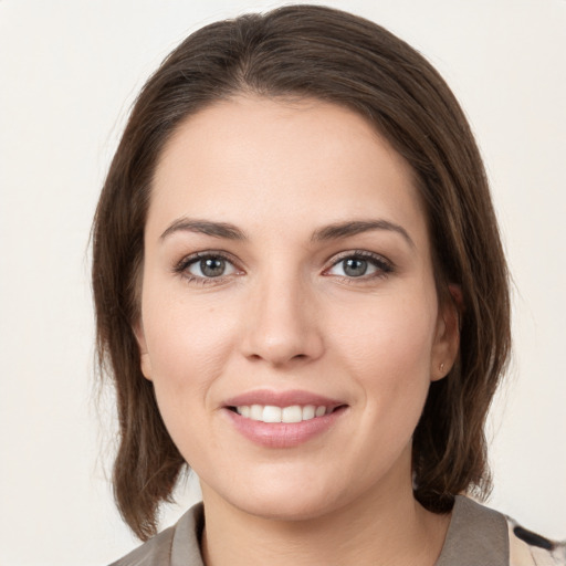 Joyful white young-adult female with medium  brown hair and grey eyes