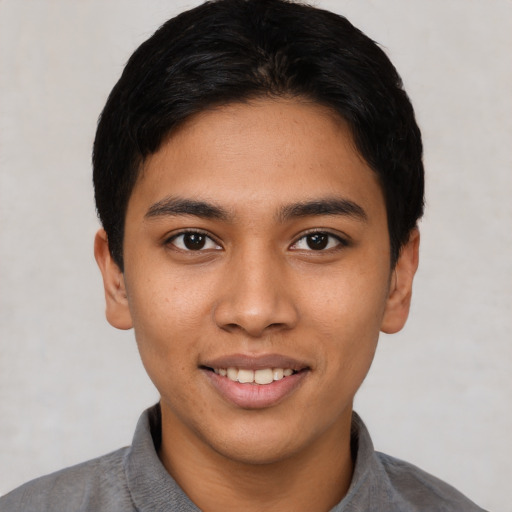 Joyful latino young-adult male with short  black hair and brown eyes