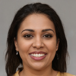 Joyful latino young-adult female with medium  brown hair and brown eyes