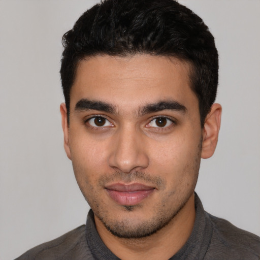 Joyful latino young-adult male with short  black hair and brown eyes