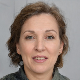 Joyful white adult female with medium  brown hair and grey eyes