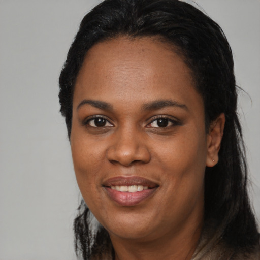 Joyful black adult female with long  black hair and brown eyes