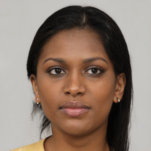 Joyful black young-adult female with long  brown hair and brown eyes