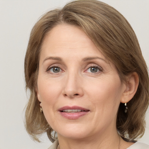 Joyful white adult female with medium  brown hair and grey eyes