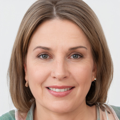 Joyful white young-adult female with medium  brown hair and grey eyes