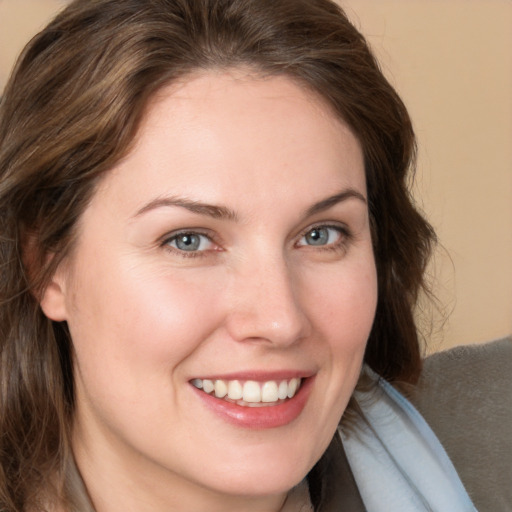 Joyful white young-adult female with medium  brown hair and green eyes