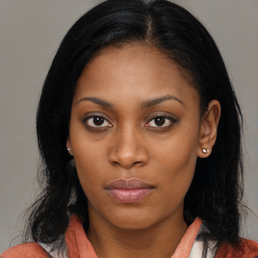 Joyful black young-adult female with long  black hair and brown eyes