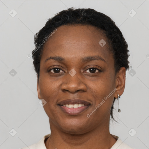 Joyful black young-adult female with short  black hair and brown eyes