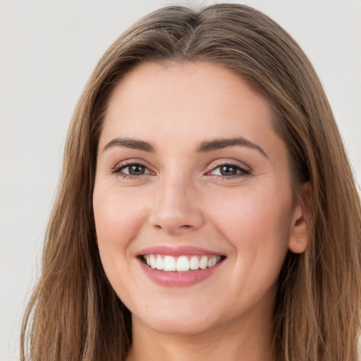 Joyful white young-adult female with long  brown hair and grey eyes