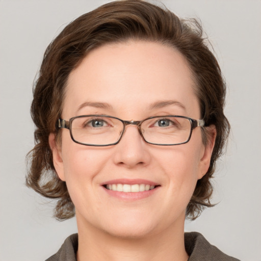 Joyful white adult female with medium  brown hair and grey eyes