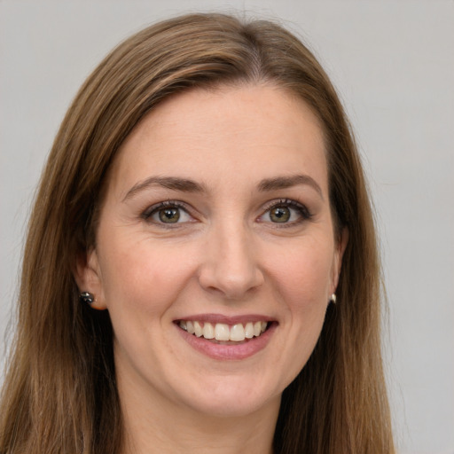 Joyful white young-adult female with long  brown hair and green eyes