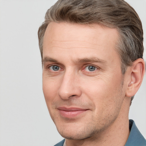 Joyful white adult male with short  brown hair and grey eyes