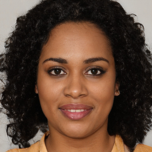 Joyful black young-adult female with medium  brown hair and brown eyes