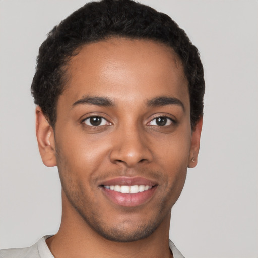 Joyful black young-adult male with short  brown hair and brown eyes