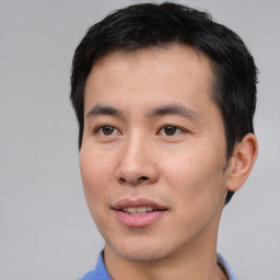 Joyful asian young-adult male with short  black hair and brown eyes