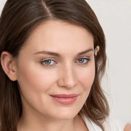 Joyful white young-adult female with long  brown hair and blue eyes