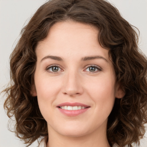 Joyful white young-adult female with long  brown hair and green eyes