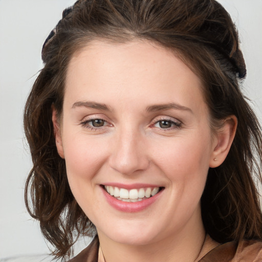 Joyful white young-adult female with long  brown hair and grey eyes