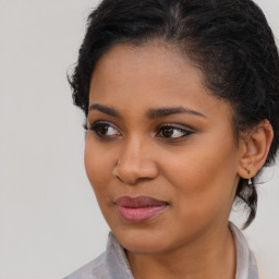 Joyful black young-adult female with long  brown hair and brown eyes