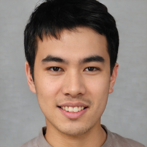 Joyful asian young-adult male with short  brown hair and brown eyes