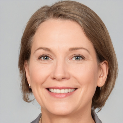 Joyful white adult female with medium  brown hair and grey eyes