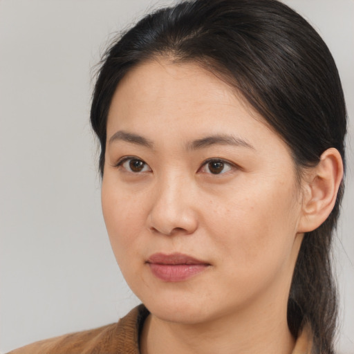 Joyful asian young-adult female with medium  brown hair and brown eyes