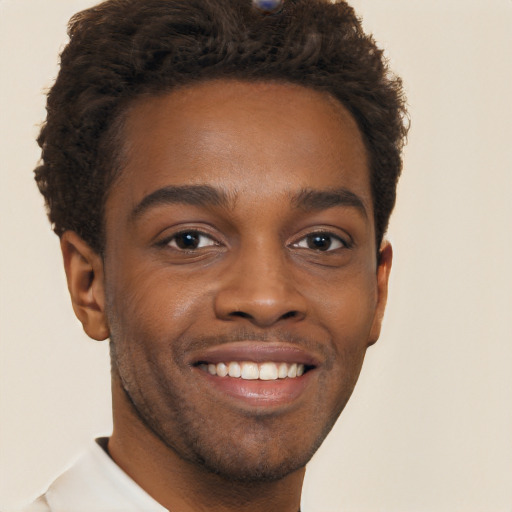 Joyful black young-adult male with short  brown hair and brown eyes