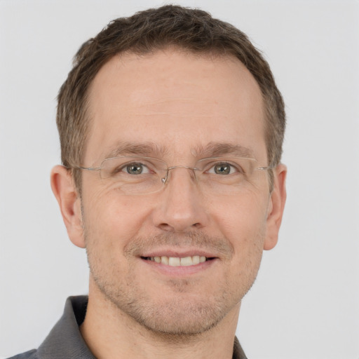 Joyful white adult male with short  brown hair and grey eyes