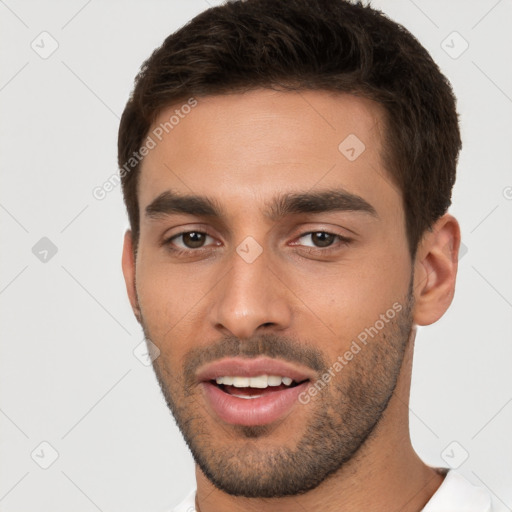 Joyful white young-adult male with short  brown hair and brown eyes