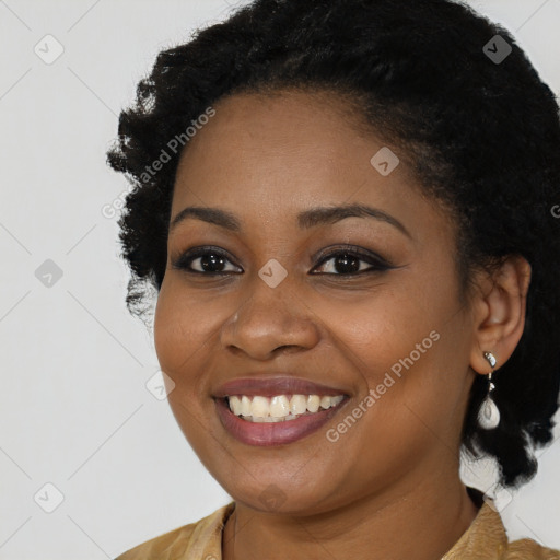 Joyful black young-adult female with long  black hair and brown eyes